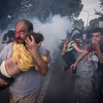 A migrant holds his child during a clash with Hungarian riot police at the Horgos border crossing in Serbia.