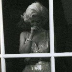 Marilyn Monroe, pencereden bakıyor. Arkada ABD Başkanı Kennedy beline sarılmış vaziyette
