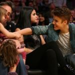 justin-bieber-and-selena-gomez-kiss-at-lakers-game-and-pose-with-young-fan-3-580×435